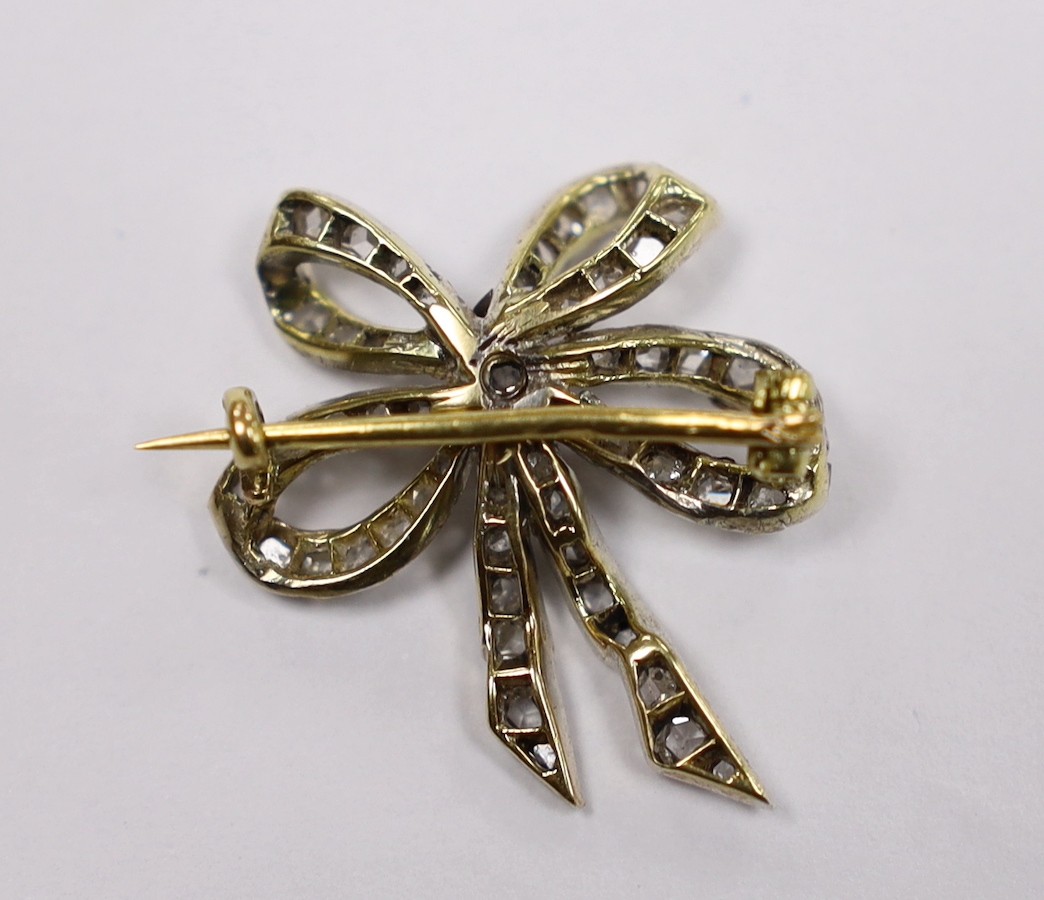 An early 20th century Austro-Hungarian yellow metal and diamond cluster set ribbon bow brooch, 26mm, gross weight 3.8 grams.